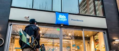 A modern building with a glass facade and a sign for 'ibis budget'.