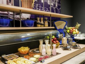 A buffet setup with various food items, including fruits, juices, and condiments. - Ibis Budget Santiago Providencia (Santiago)