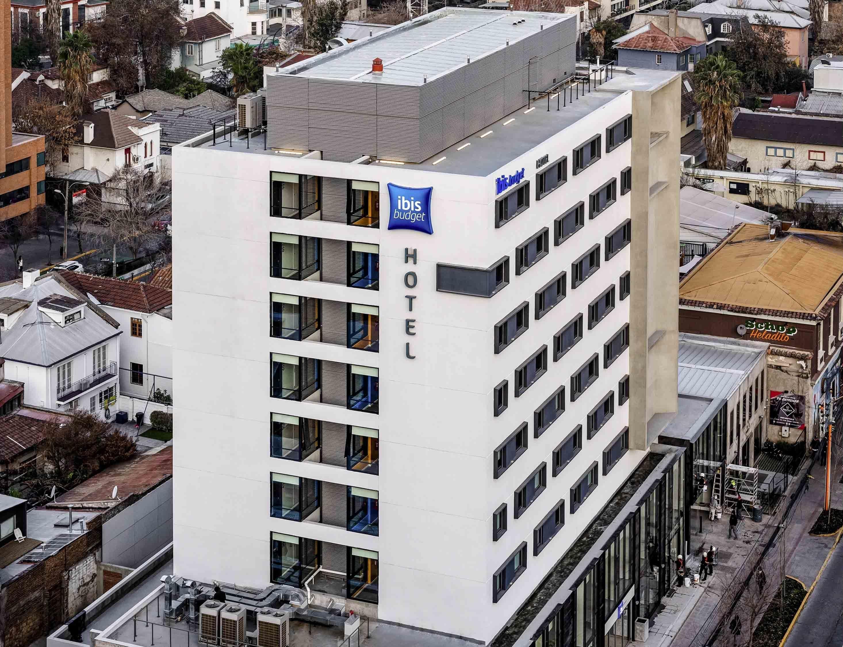 Un hotel moderno con fachada blanca, varios pisos y techo plano.