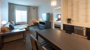 A modern hotel room with a dining area, a sofa, a TV, and a kitchenette. - Residence Inn by Marriott Minneapolis Maple Grove/Arbor Lakes (Maple Grove)