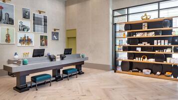 Enjoy a stylish space with a long table, cushioned benches, and a unique shelving unit displaying a collection of books and decorative items.
