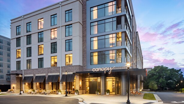 Een hotel met meerdere verdiepingen en een modern ontwerp, met een opvallend 'canopy' bord bij de ingang.