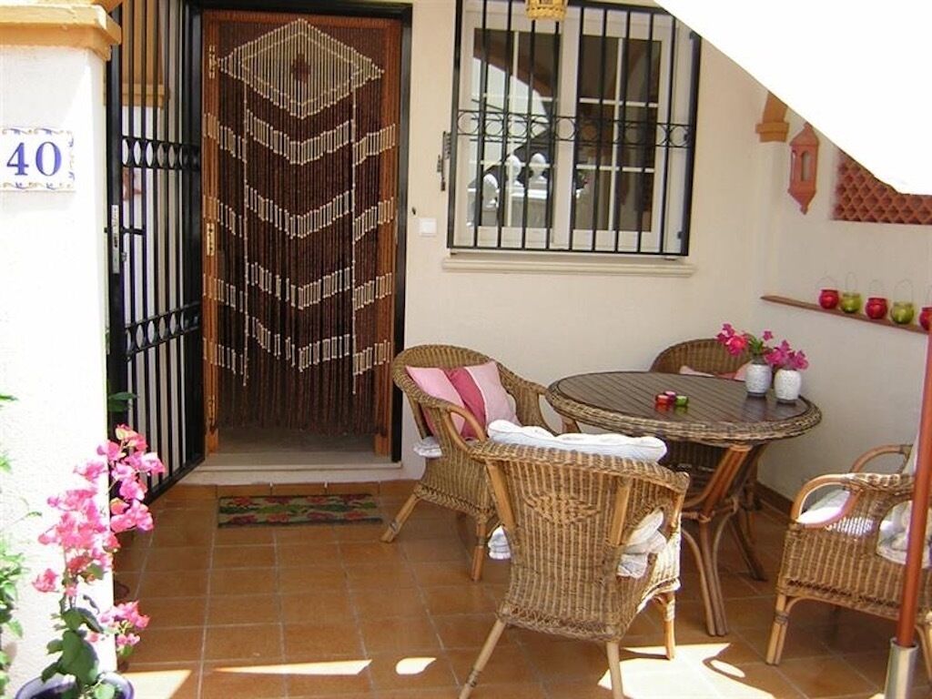 A patio with wicker furniture, a tiled floor, and a door with a decorative pattern.
