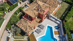 Une propriété résidentielle dotée d’une piscine, d’un toit en tuiles et d’un jardin.