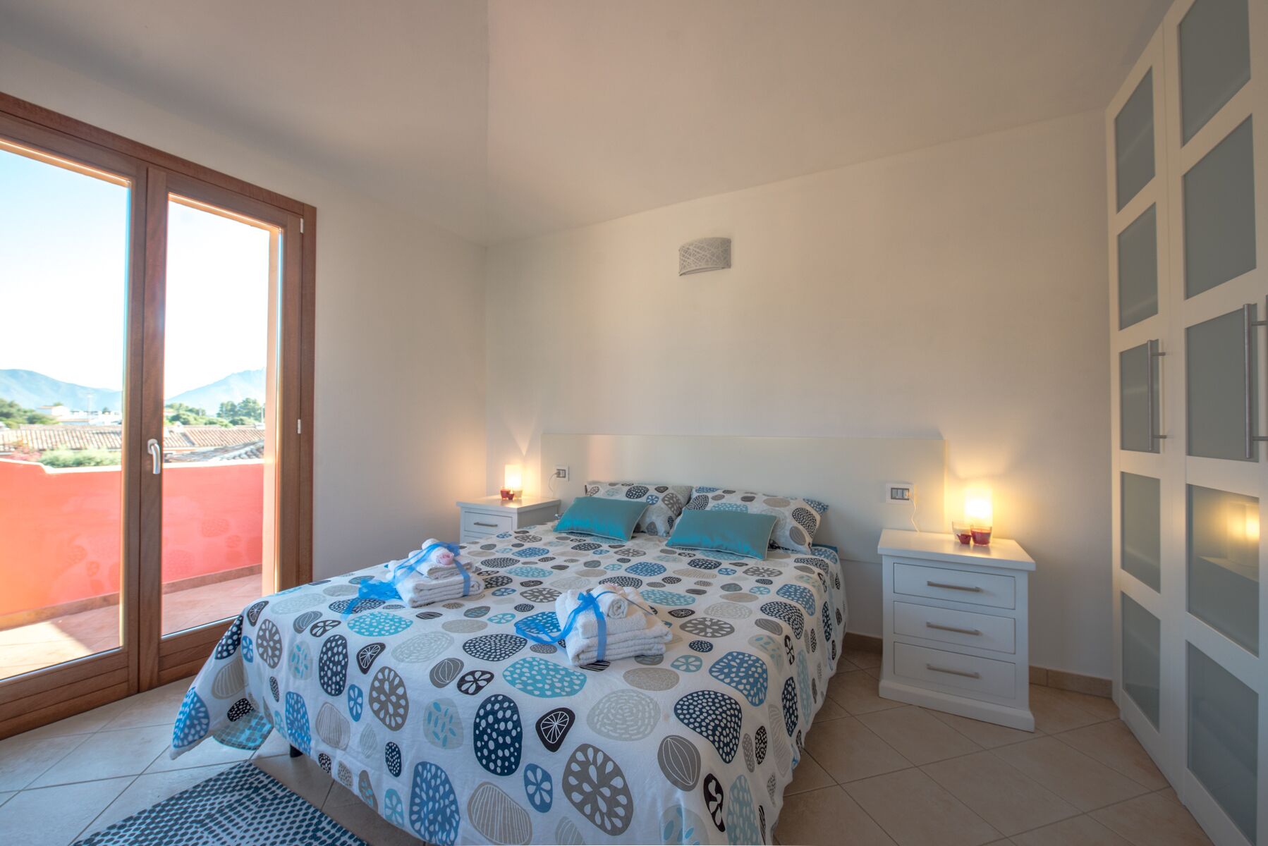 Un dormitorio con cama, dos mesitas de noche y ventana con vistas al exterior.