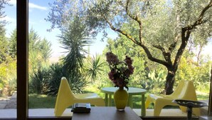 A room with a large window, a table with a vase of flowers, and yellow chairs. - ATELIER DEI CILIEGI (CAMMARATA)