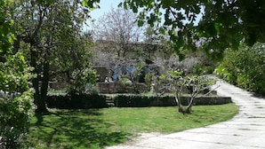 A pathway leading through a garden with stone walls and trees. - ATELIER DEI CILIEGI (CAMMARATA)