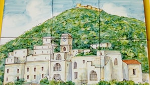 Ein Kachelmosaik einer Stadt mit einem markanten Hügel und einer Kirche mit einem Glockenturm.