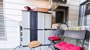 A balcony with two chairs, a small table, and a potted plant.