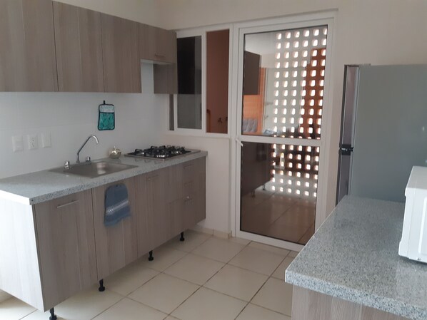 Microondas, cafetera y tetera, utensilios de cocina y condimentos 