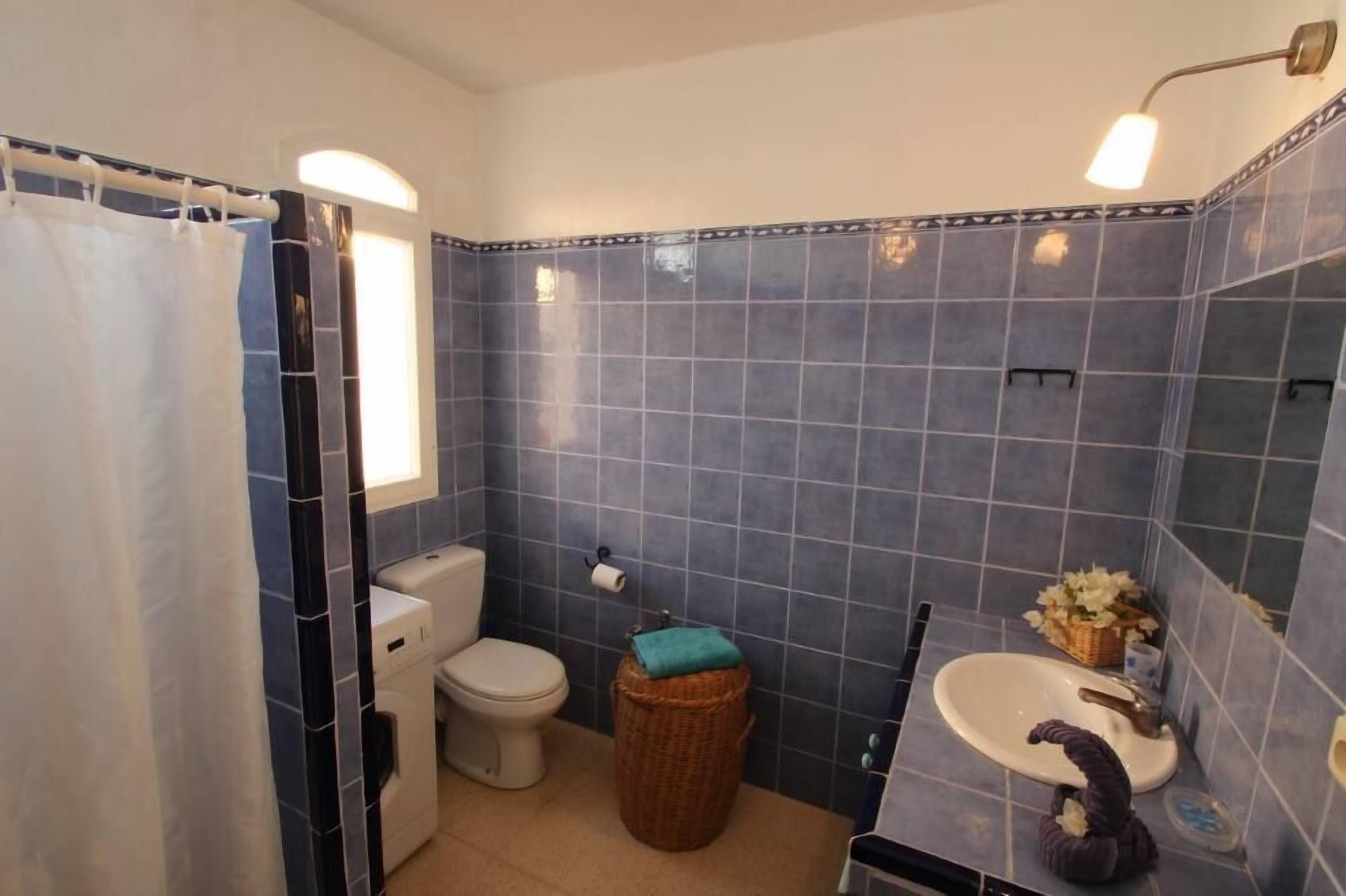 Een badkamer met toilet, wastafel en douche.