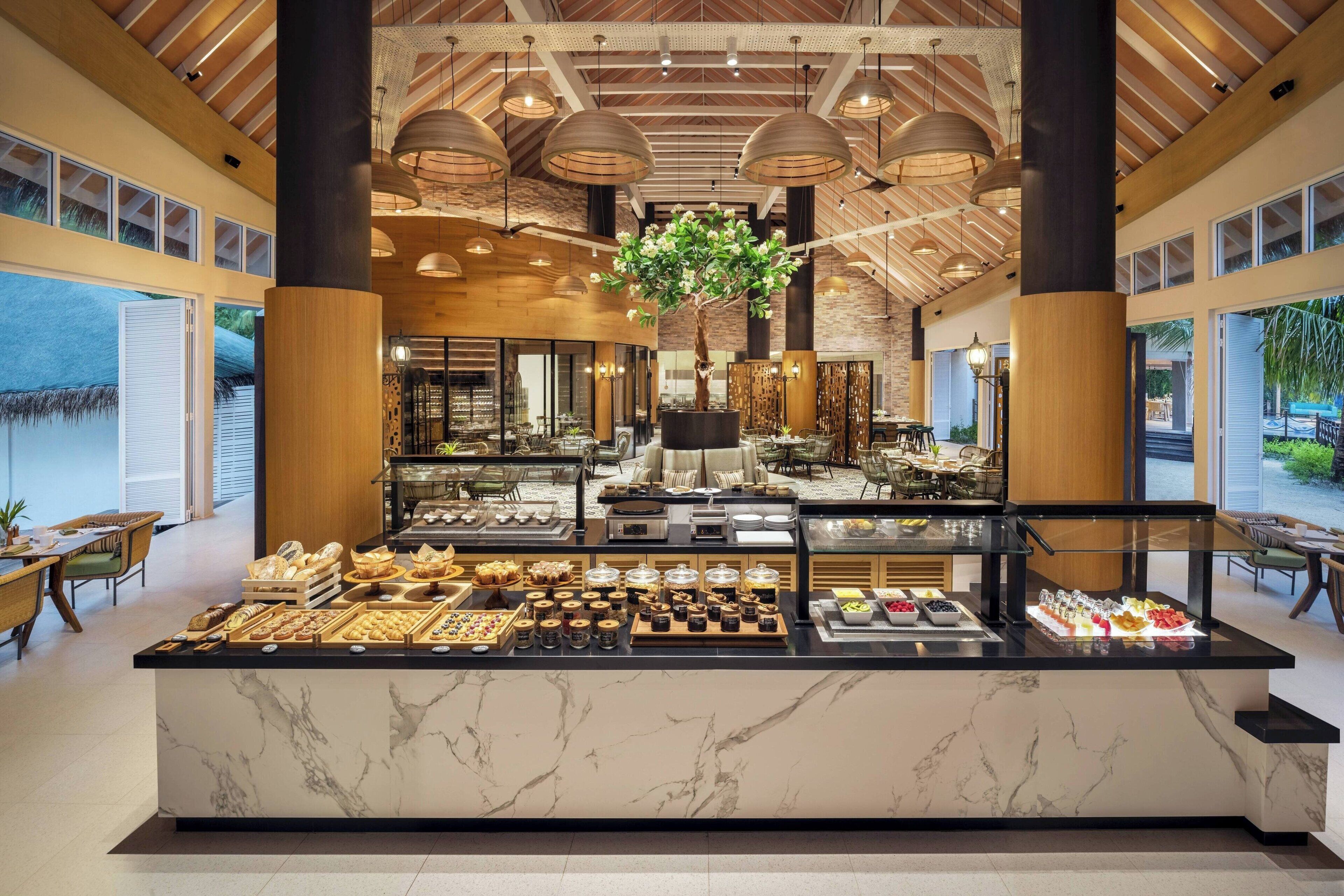 Un espace buffet proposant une variété de plats et agrémenté d’un arbre décoratif central.