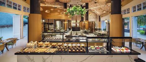 Un espace buffet proposant une variété de plats et agrémenté d’un arbre décoratif central.