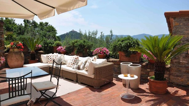 A patio with a wicker sofa, chairs, a table, and potted plants. - LAST MINUTE OFFER! Jacuzzi pool, Sauna, A / C, WiFi, close beaches & 5 Terre (ORTONOVO)