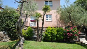 A two-story building with a stone foundation, a pink facade, and a balcony with a flower pot. - LAST MINUTE OFFER! Jacuzzi pool, Sauna, A / C, WiFi, close beaches & 5 Terre (ORTONOVO)