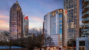 Een stadsbeeld met moderne wolkenkrabbers, waaronder een hotel met een opvallende rood-witte gevel.