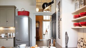 A modern kitchen with a refrigerator, coffee maker, and breakfast items on the counter. - A fusion of Georgian and Modern. Impeccably furnished with excellent attention to detail! (Edinburgh)