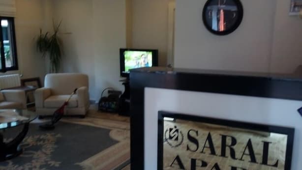 A reception area with a sign reading "SARAL APART" and a television in the background. - Saral Apart (Atakum)
