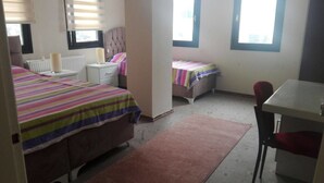 A bedroom with two beds, a desk, and a chair. - Saral Apart (Atakum)