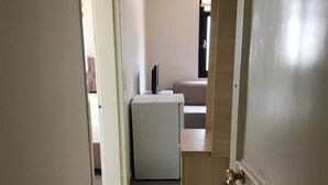 A hallway leading to a living area with a sofa and a television. - Saral Apart (Atakum)