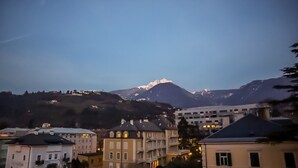 A town with buildings and a mountain in the background. - Central, spacious and comfortable, easy to reach by car or train. (Merano)