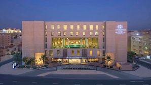 A hotel with a modern facade, a central atrium, and a sign indicating it is a DoubleTree by Hilton. - DoubleTree by Hilton Doha - Al Sadd (Doha)