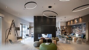 A modern interior with a central seating area, a fireplace, and a view of the outdoors. - Be Place (Trento)
