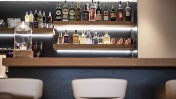 A bar area with shelves of various liquor bottles and glasses.
