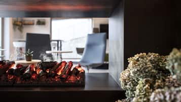 A modern interior with a charcoal grill, a seating area, and a potted plant.