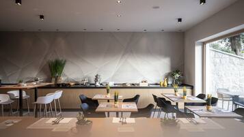 A modern dining area with a geometric wall design, wooden tables, and chairs.