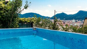 Une piscine offrant une vue sur le paysage urbain et les montagnes en arrière-plan.