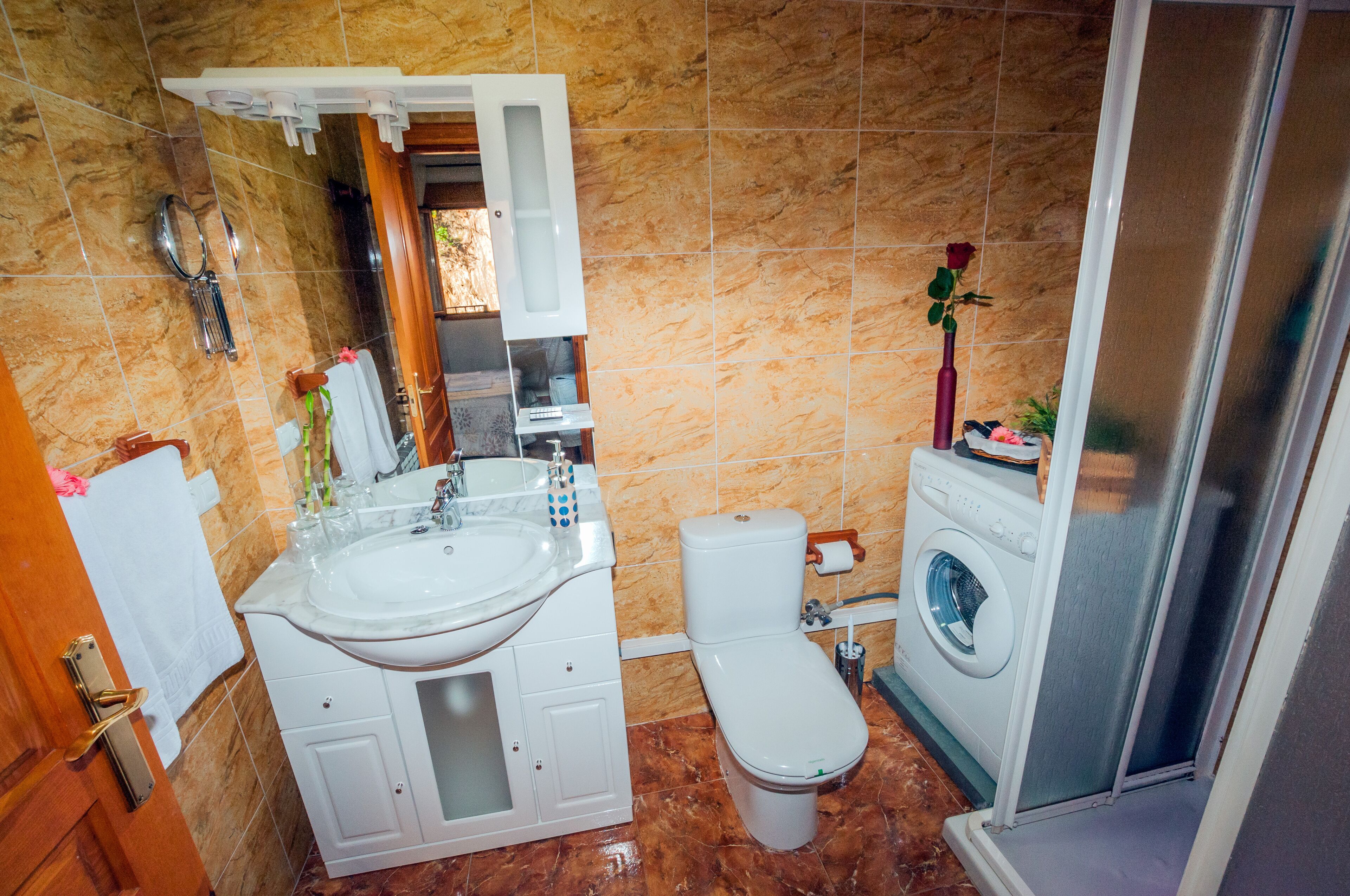 A bathroom with a sink, toilet, and washing machine.