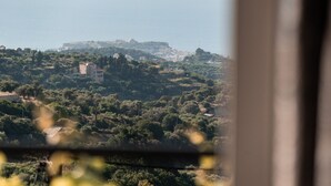 A coastal landscape with buildings, trees, and a distant fortification. - Charmful villa, stunning views,pool, hot tub & BBQ (Roussospiti)