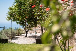 Un sentier qui mène à une plage, avec un arbre et une clôture en arrière-plan.