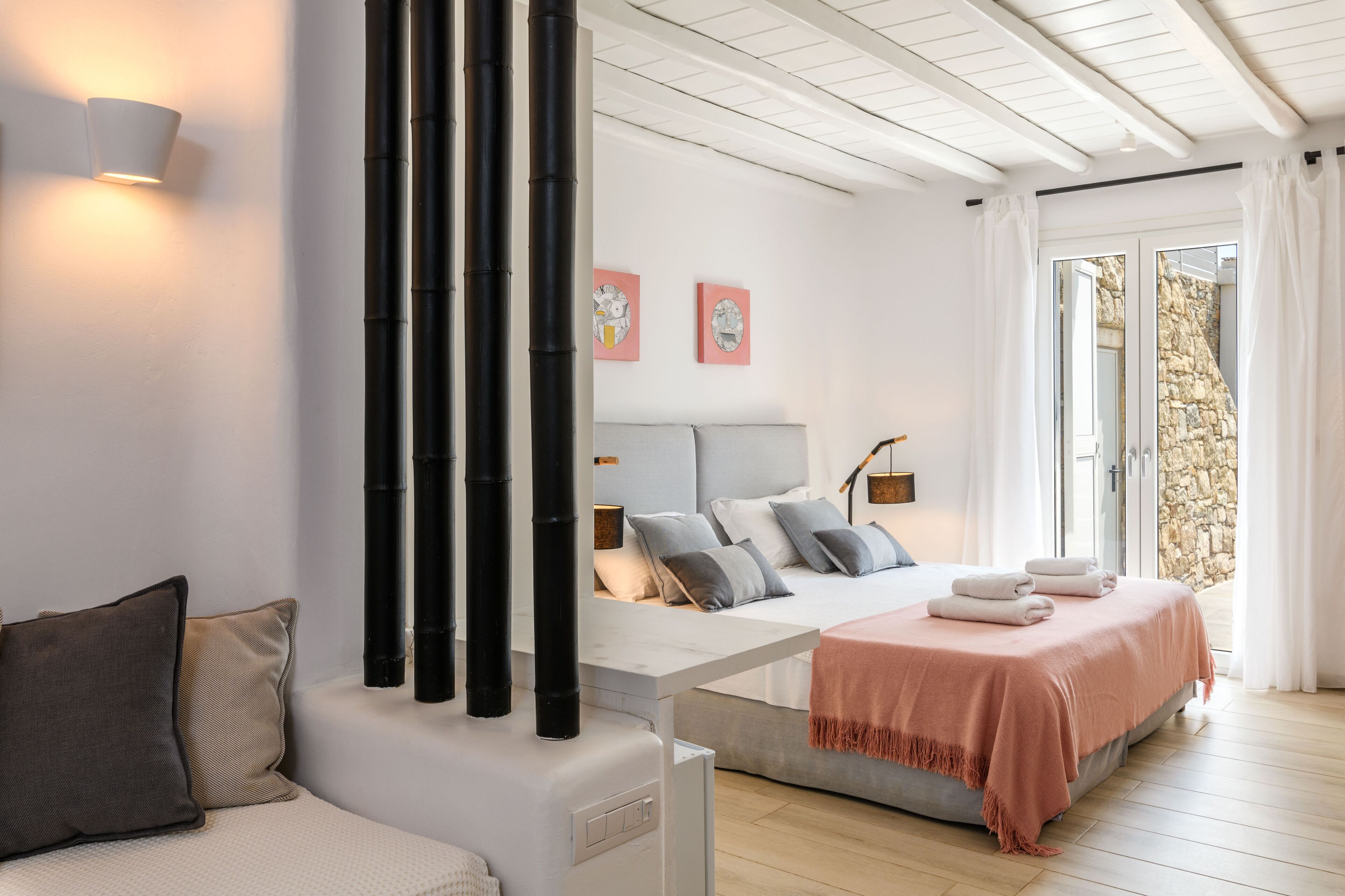 Un dormitorio moderno con una cama, mesita de noche y vistas al exterior.