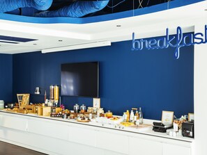 A breakfast buffet with various food items and a large TV screen on the wall. - ibis Styles Paris Orly Airport (Paray-Vieille-Poste)
