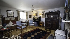 A traditional living room with a piano, a fireplace, and a large rug. - Carrowcullen, The Old Irish Farmhouse (Skreen, Ireland)