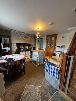A rustic kitchen with a stone wall, wooden cabinets, and a central island. - Carrowcullen, The Old Irish Farmhouse (Skreen, Ireland)
