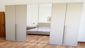 A bedroom with a large wardrobe, a bed, and a wooden floor. - crotone house via S Leonardo (Crotone)