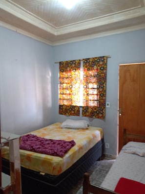 Cozy retreat with a bed, bedside table, and chair, offering a peaceful space to unwind.
