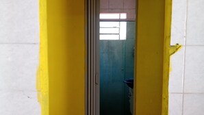 A narrow hallway with yellow walls and a tiled floor.