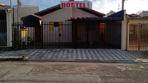 A hostel with a gated entrance, a checkered pavement, and a sign indicating it is in Taubateks, Texas.