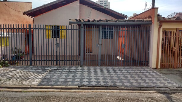 A gated residential area with a checkered pavement leading to a gated entrance.