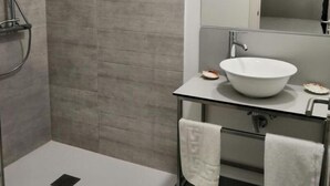 A modern bathroom with a glass-enclosed sink, a large mirror, and a walk-in shower. - Studio with sea views (APT 1) (Combarro)