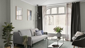 Un salon moderne avec un canapé gris, une table basse et une plante en pot.