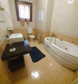 Bathtub, hair dryer, bathrobes, towels