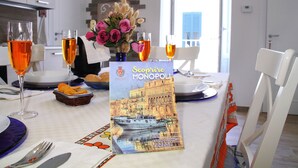 Ein Esstisch mit einer Speisekarte, zwei Gläsern mit Orangensaft, einer Vase mit rosa Rosen und einem Teller mit Croissants.