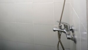 A shower with a handheld showerhead and a flexible hose. - OYO 1125 Sani Guest House (Balikpapan)