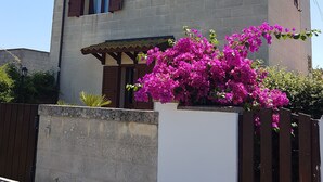 Um edifício com fachada de pedra, persianas de madeira e uma varanda.