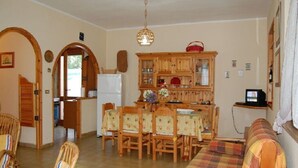 A dining area with a wooden table and chairs, a buffet cabinet, and a television.